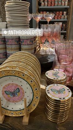 a table topped with lots of plates and glasses filled with pink wineglasses next to each other