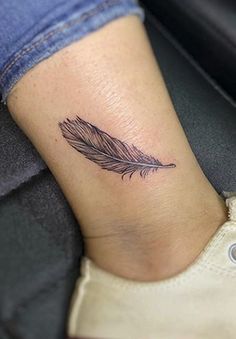 a small feather tattoo on the ankle