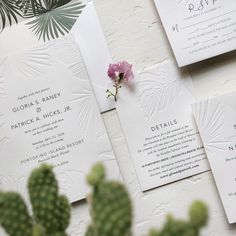 the wedding stationery is laid out on top of each other, with a pink flower