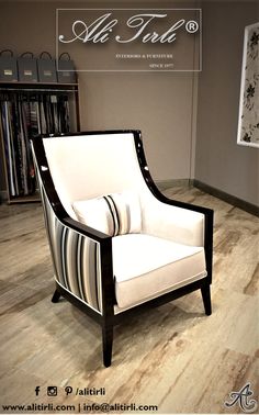 a white and black chair sitting on top of a hard wood floor next to a book shelf