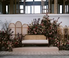 a couch sitting in front of a bunch of flowers on display at a wedding ceremony