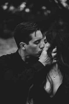 a man and woman kissing each other in black and white