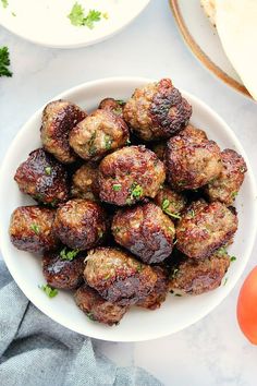 a white bowl filled with meatballs on top of a table