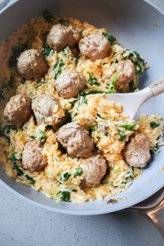 meatballs and rice in a skillet with a wooden spoon on the side, ready to be eaten