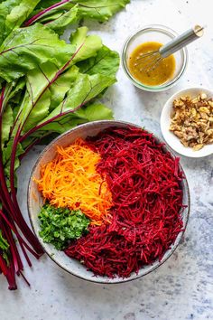 a bowl filled with different types of vegetables next to other ingredients on a counter top