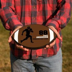 a man holding a football with the number 25 on it