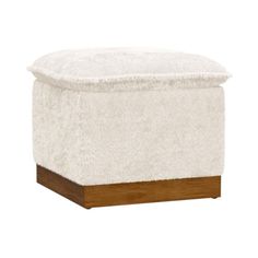 a small white ottoman with wooden legs