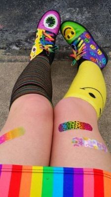 the legs and feet of a person wearing colorful socks with smiley face patches on them