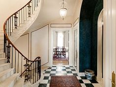 an entry way with stairs and rugs on the floor