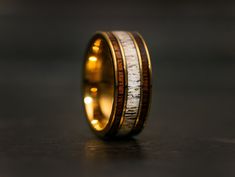 a gold ring with antler and wood inlays on the inside of it