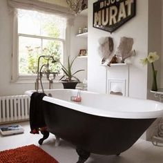 a bathroom with a claw foot bathtub and rug