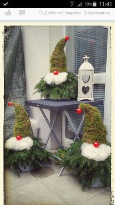 three gnome hats sitting on top of an ironing board covered in pine needles and red berries