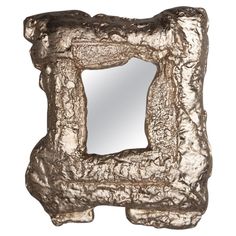 a mirror that is sitting on top of a white surface with silver foil covering it