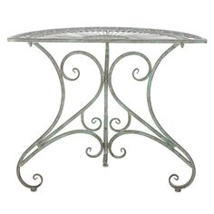 an ornate iron table with white marble top and scrolled design on the base, against a white background