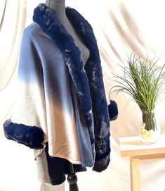 Introducing our luxurious Ombre Navy Blue Cape, a must-have addition to your winter wardrobe. Made from a blend of warm Wool and Acrylic fibers, this cape features a beautiful faux fox fur trim that adds a touch of elegance to any outfit. The wide and exceptionally soft fur trim wraps around the neck and cascades down the front for ultimate warmth and style. Its open front design and oversize cardigan style make it suitable for most women, with a bust measurement of 93 inches / 236cm, cloak length of 30 inches / 78cm, and sleeve length (with shoulders) of 23 inches / 60cm. This Ruana is not just a functional piece of outerwear, but also a statement fashion piece. The man-made, lush and fluffy fox fur trim gives the cape an extravagant and expensive appearance, adding sophistication and fla Statement Fashion Pieces, Faux Fur Wedding, Bridal Coat, Faux Fur Cape, Wedding Fur, Ladies Poncho, Poncho Style, Poncho Cape, Ombre Color