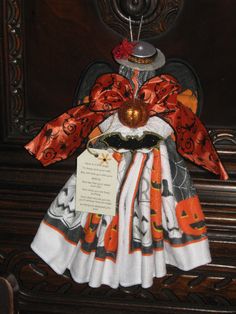 a dress made out of fabric with a pumpkin on the front and an orange ribbon around the neck