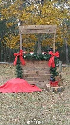 an old wooden box is decorated with red bows and greenery for a rustic wedding