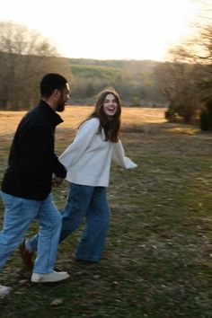 a man and woman are walking in the grass