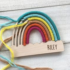 a wooden rainbow with the name riley hanging on it's side and four strings attached to it