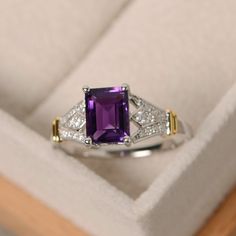 an amethorate and diamond ring in a box