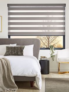 a bed sitting under a window covered in blinds