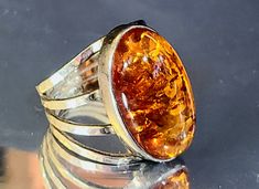 "Chunky Natural Baltic Amber is set into a hand made modern sterling silver ring. Let your hands do the talking with this timeless Amber ring. It is a perfectly crafted cognac Baltic Amber hand-hammered in 925 Hallmarked Silver. Handcrafted to a standard of perfection, it will make a unique  birthstone ring, or the perfect gift for yourself or your special someone.  DETAILS: Length on finger:  1\" inch (2.5cm)     shank tapers to 6mm wide at bottom center. Metal:  925 Sterling Silver (10.68 grams) Gemstone:  Natural Cognac Baltic Amber (25mm x 15mm) High Dome Cabochon Size:  10 Unisex Hallmarks:  925     POLAND   8-A Condition:  EXCELLENT Vintage 9.5/10 This modernist ring is the perfect ring for a tailored business look to an every day Boho vibe. Size 10. Comes in a Free Luxury Gift Ring Shifting Closet, Vintage Jewelry Antique, Small Collectibles, Modernist Ring, Hippy Gifts, Amber Ring, Kansas City Mo, 925 Silver Ring, Amber Jewelry