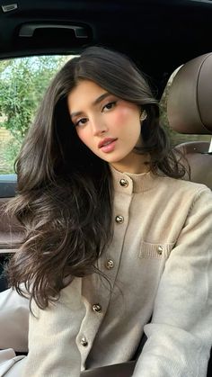 a woman sitting in the back seat of a car with her hand on her hip