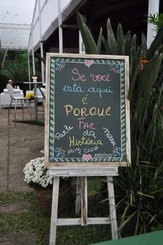 a chalkboard sign in front of some plants