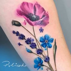 a watercolor tattoo with blue and purple flowers