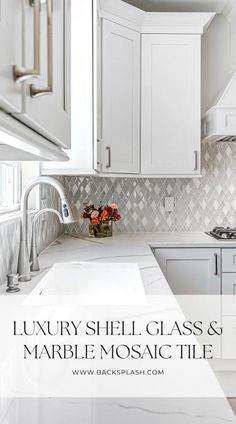 a kitchen with white cabinets and marble counter tops