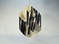 a black and white lamp hanging from a ceiling fixture in the shape of an abstract design