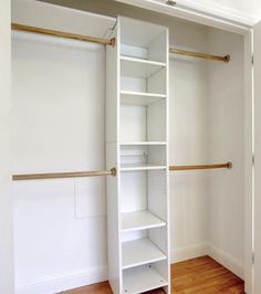 an empty closet with white shelves and wooden floors