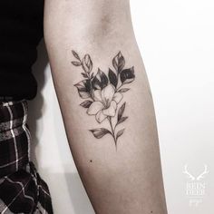 a black and white flower tattoo on the arm