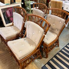 four chairs and a table in a room with rugs on the floor next to each other