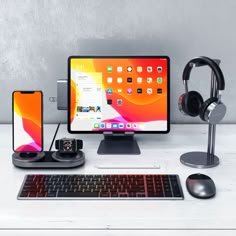 an apple desktop computer with headphones, keyboard and mouse on a desk next to it