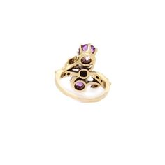 A fine toi et moi gold, amethyst, and pearl cocktail ring.  Size 2.  In 14 karat yellow gold.  The gold setting with a flower to either side of the stones and with decorative rivets/beading.  Set two round cut amethysts with a pearl in the center of the trio of stones. The amethysts have inclusions.  Simply a wonderful ring!  Date: 20th Century  Overall Condition: It is in overall good, as-pictured, used estate condition with some fine & light surface scratches and other signs of expected light wear consistent with age.  Fineness: Marked 14k for gold fineness.   Marks: Marked 14k to the shank.   Ring Size: ca. 2  Gemstone Measurements: 2 Amethyst: ca. 5.5mm diameter x 3.25mm height 1 Pearl: ca. 4mm diameter  Measurements: Height: ca. 17mm Width: ca. 18mm Depth: ca. 21mm  Weight: ca 3.3 g Vintage 14k Gold Multi-stone Amethyst Ring, Vintage Multi-stone Amethyst Ring In 14k Gold, Antique Gold Amethyst Multi-stone Ring, Antique Gold Amethyst Ring With Multi-stone, Yellow Gold Three Stone Amethyst Ring, Anniversary Yellow Gold Three-stone Amethyst Ring, Three Stone Amethyst Ring In Yellow Gold, Pearl Cocktail Ring, Gold Set