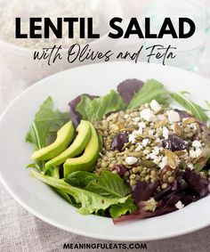 lentil salad with olives and feta in a white bowl on a table