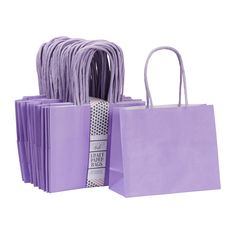 purple shopping bags are stacked on top of each other