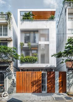 an apartment building with wooden doors and plants growing on the side of it's windows