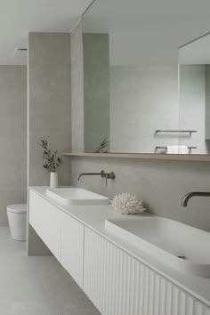 a bathroom with two sinks and a large mirror