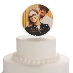 a white cake with a photo on top and frosting around the edges is shown