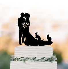 a wedding cake topper with a silhouette of a couple and their dog