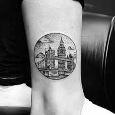 a black and white photo of a cityscape tattoo on the right side of the leg