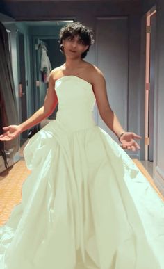 a woman in a white wedding dress is posing for the camera