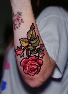 a woman's arm with a rose tattoo on it