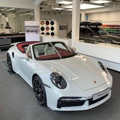 a white sports car parked in a showroom