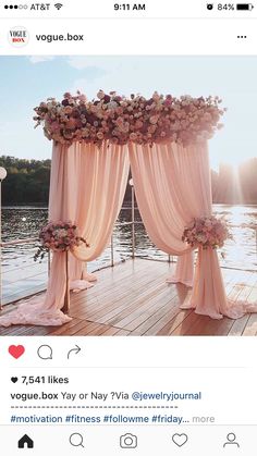 an outdoor wedding ceremony setup with pink draping and flowers on the side of it