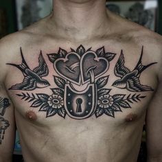 a man with tattoos on his chest has a lock and two birds