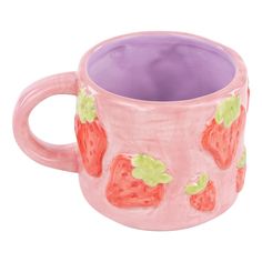 a pink mug with strawberries painted on it