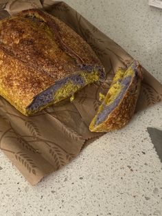 a loaf of bread sitting on top of a piece of brown paper next to a knife